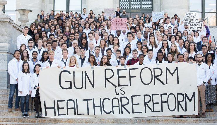 Mass General Hospital workers holding "Gun Reform is Health Care Reform" banner